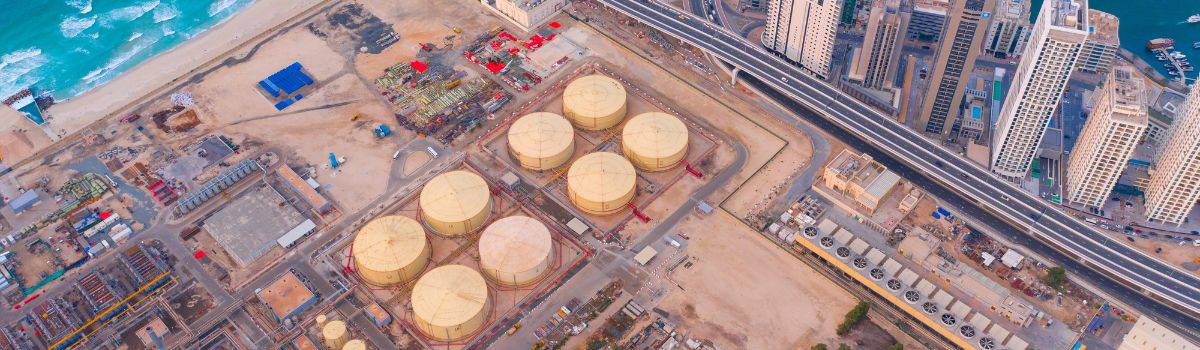 Aerial view of petrochemical oil refinery and sea in industrial engineering and energy concept in Dubai, urban city, UAE. Oil and gas tanks pipelines in industry. Modern metal factory. Power plant